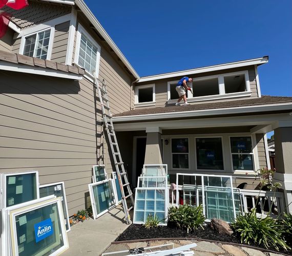 Professional window replacement by Supreme Contractors at a two-story home in Roseville, CA featuring new energy-efficient Anlin vinyl windows.