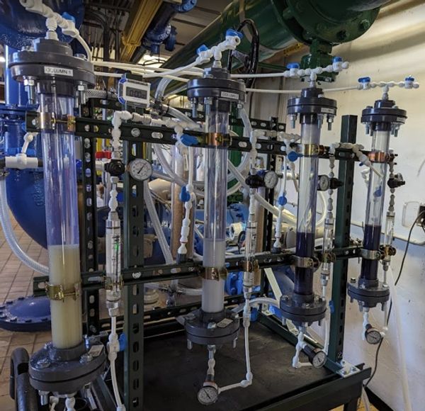 Industrial filtration system with multiple transparent cylinders and gauges.