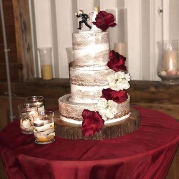 Naked vanilla cake, decorated with a light layer of cream and natural flowers