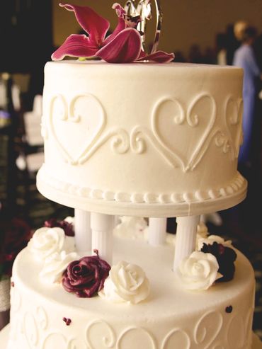 Two-tier coconut-flavored cake, decorated with buttercream and fondant flowers