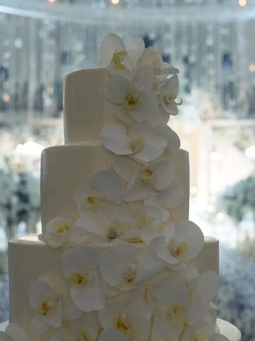 Three-tier orange-flavored cake, decorated with delicious buttercream and fondant flowers