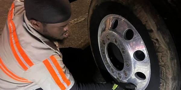 Worker fixing a wheel with a reflective cover at night.