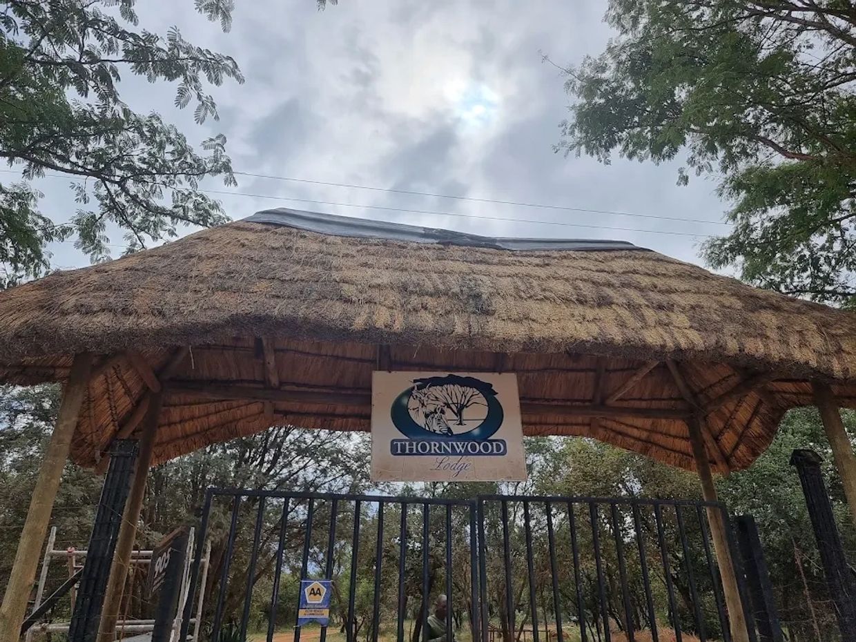 Entrance gate of Thornwood with a thatched roof.