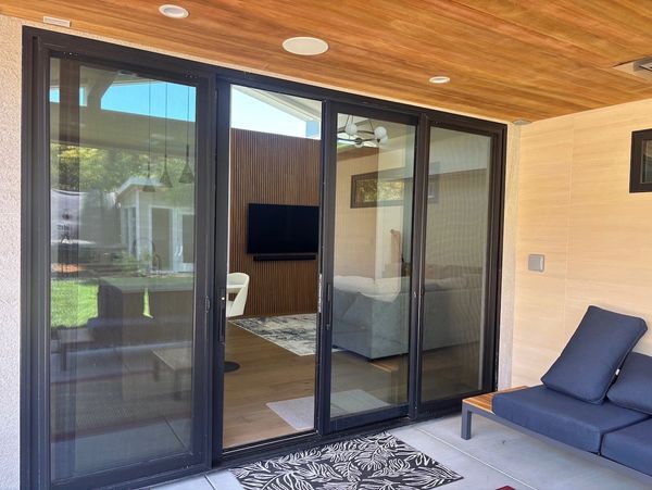 Modern sliding glass doors open to a cozy living room.