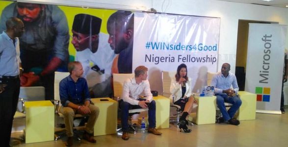 4 people are sitting in chairs in a ballroom with a #WInsiders4Good Nigeria poster behind them