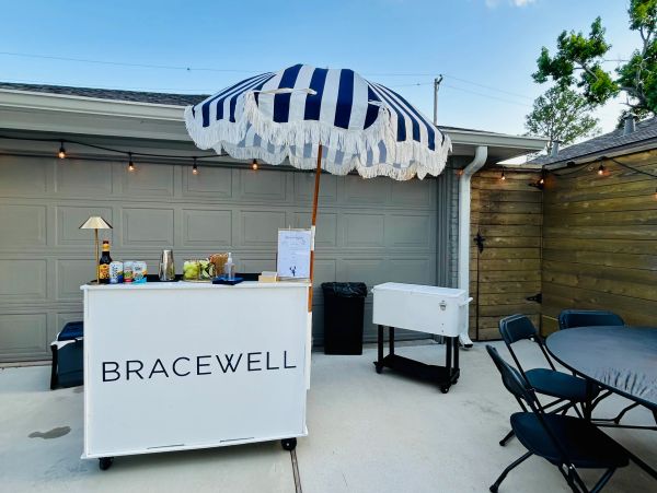 Outdoor bar setup with striped umbrella and seating area.