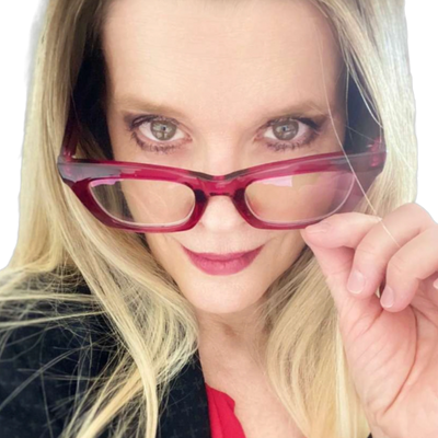 Close up of a women peaking from behind her red reading glasses.