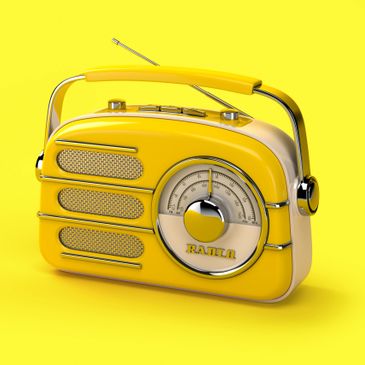 Old yellow transistor radio with handle and antenna.