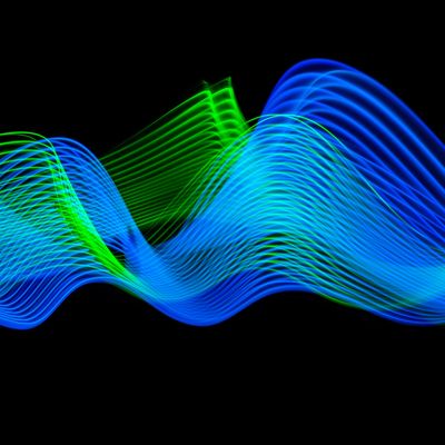neon blue and neon green sound waves on black backdrop