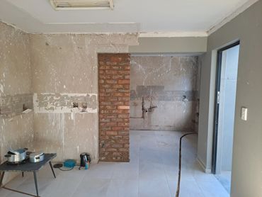 Unfinished room with exposed brick, cooking pots, and electrical outlets.