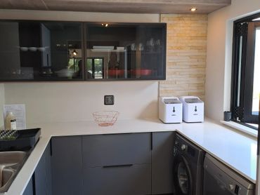 Modern kitchen with sleek grey cabinets and white countertops.