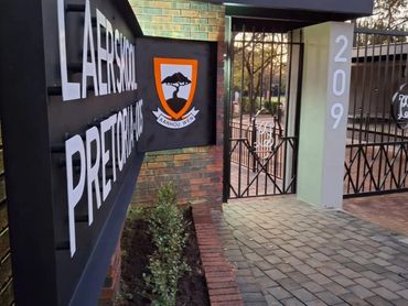 Entrance gate of Laerskool Pretoria-Oos with school emblem and address number 209.