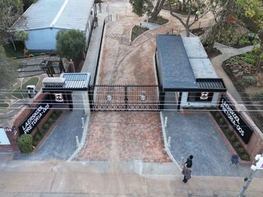 Entrance gate of Laerskool Pretoria-Oos with brick pathways and greenery.
