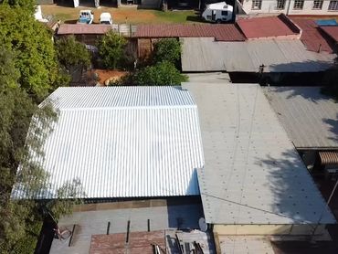 Aerial view of various corrugated metal roofs in a residential area.