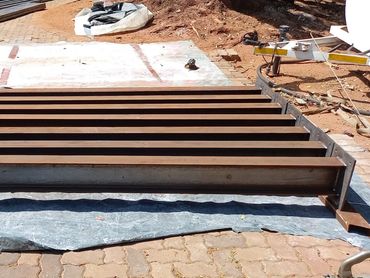 Metal beams arranged on the ground at a construction site.