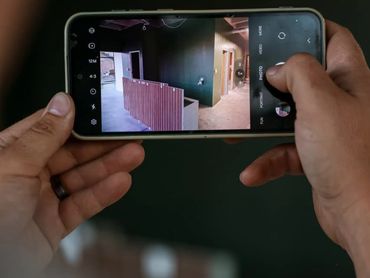 A person taking a photo of an indoor space with a smartphone camera.