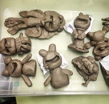 Clay sculptures of various cartoonish characters in a tray.