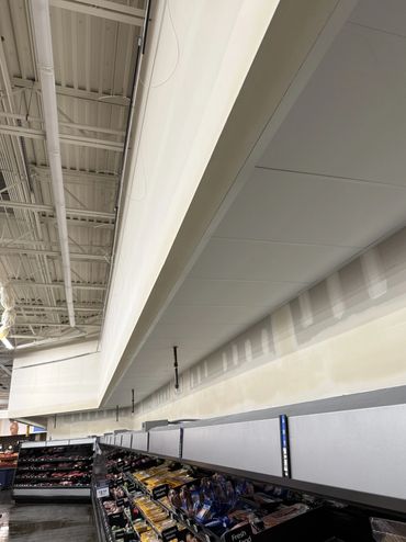 Empty grocery store meat section with covered signage.
