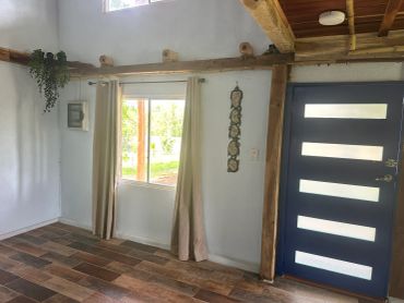Cozy room with tile floor, blue door, and window with beige curtains.