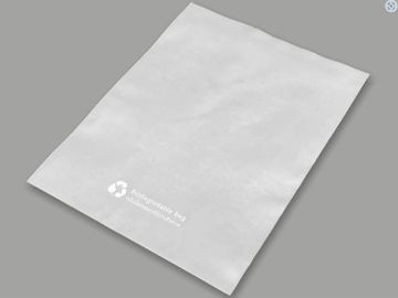 White paper bag with recycling logo on gray background.