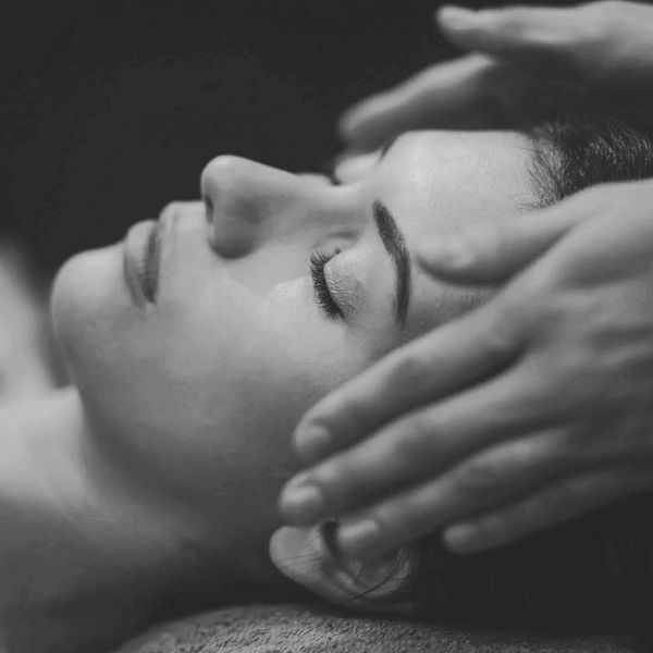 Person receiving a relaxing facial massage with closed eyes.