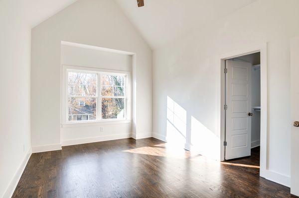 white room with hardwood floors and big windows