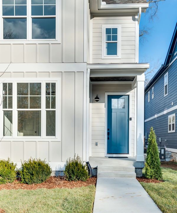 white and gray home exterior with blue door