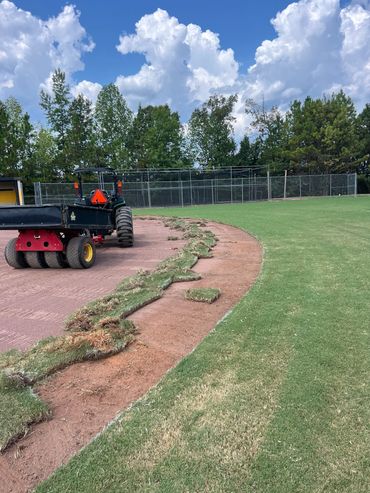 Professional Turfgrass Services managing a baseball field lips after overgrowth.