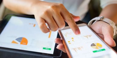 person using a smartphone and tablet to analyse information