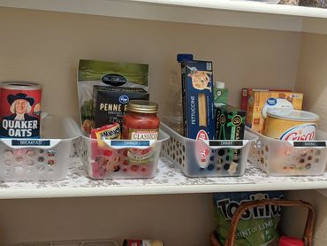 Organized pantry bins labeled for breakfast, dinner, and baking items on a shelf.