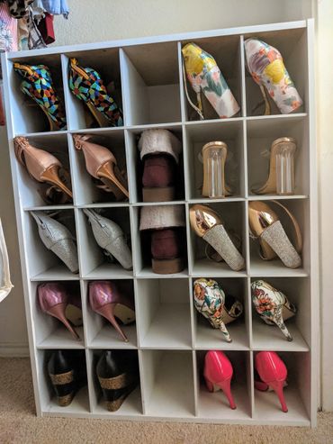 Organized white shelf with various colorful women's high heel shoes.