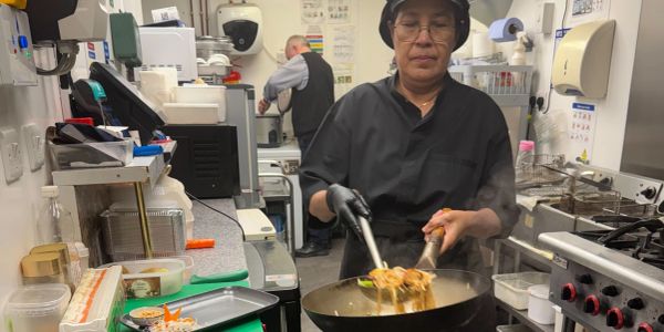 Aoy, our Chef serving noodles in a busy kitchen.