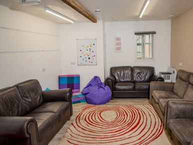 Cozy living room with leather sofas and a colorful bean bag.
