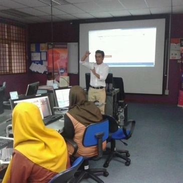 Instructor teaching a computer class with students in a lab.