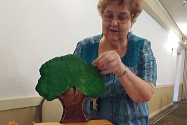 Photo of a member inserting a coin in our Tree Bank raising donations for planting trees in the comm