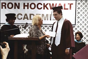 Photo of a member awarding a college scholarship to a gradating senior at Ron Hockwalt Academy.