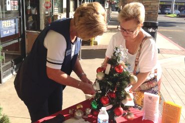 Photo of a member collecting donations for the Scholarship Tree of Lights drive.