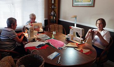Photo of volunteers sewing decorative napkins.
