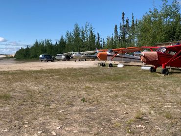 Lineup of four single engine aircraft at CKS8 Midgett Airfield, Crystal Lodge on Cree Lake