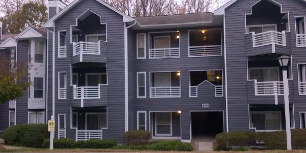 Gray apartment building with white trim and balconies.