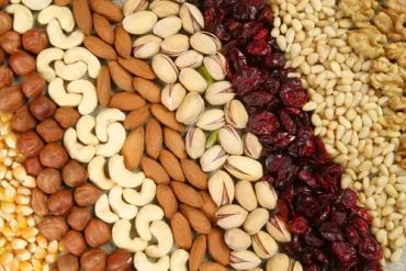 Assorted nuts and dried fruits arranged in stripes.