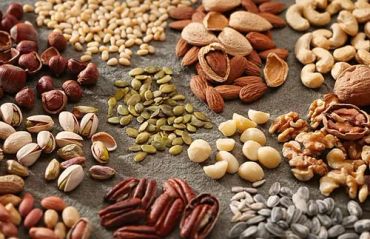 Variety of nuts and seeds on a surface.