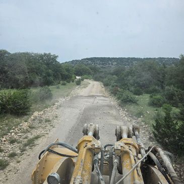 View from a bulldozer on a rough dirt road.