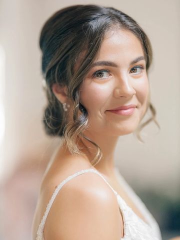 A woman with soft curls smiling gently.