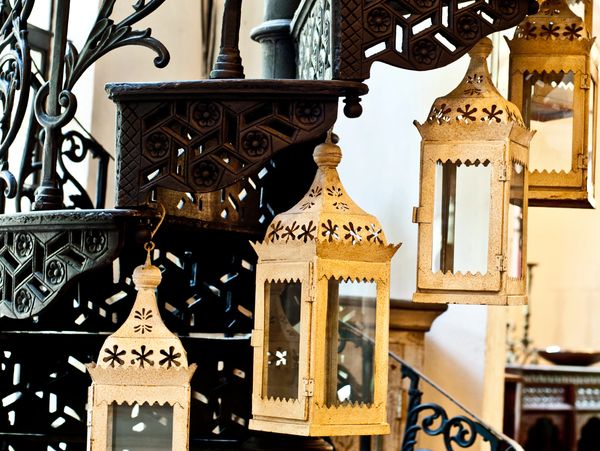 Decorative lanterns hanging on a wrought iron spiral staircase.