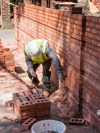 a worker constructing a wall with bricks