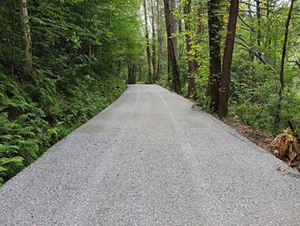 Partially constructed large wooden barn structure with an open frame under a cloudy sky.