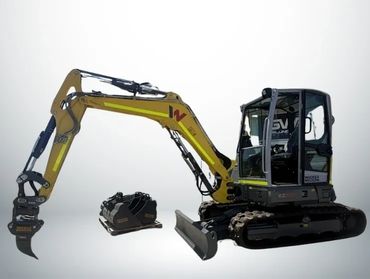 Compact yellow and black excavator with a separate bucket attachment, shown in a studio setting.