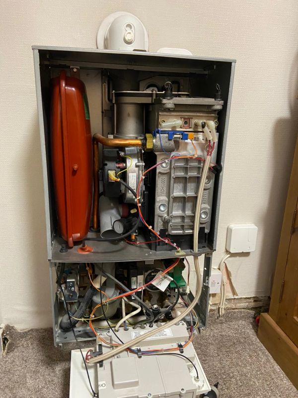 Open boiler unit showing internal pipes and components.