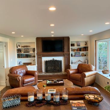 Cozy living room with brown leather chairs and fireplace.